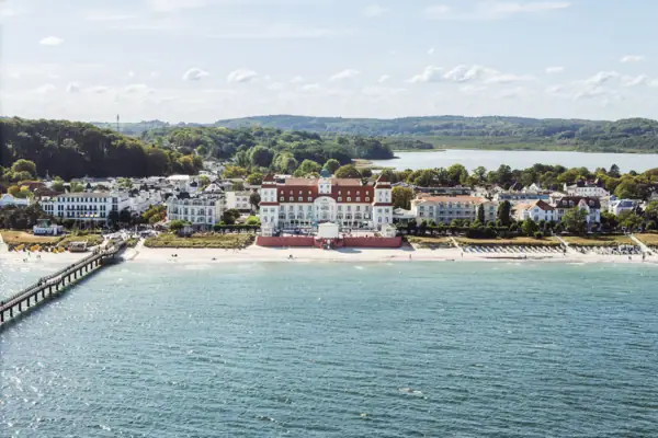 Großes weißes Gebäude neben einem Gewässer.