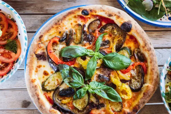 Pizza mit Gemüse auf einem Teller