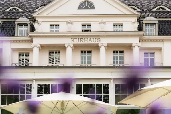 A-ROSA Travemünde Ein Gebäude mit einem großen Fenster und einem großen Sonnenschirm.