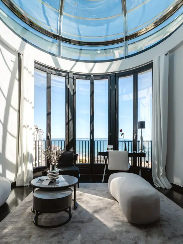 Ein Raum mit einem großen Tisch und Stühlen vor einem großen Fenster.