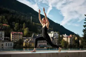Yoga Eine Frau in schwarzer Kleidung beim Yoga im Freien.