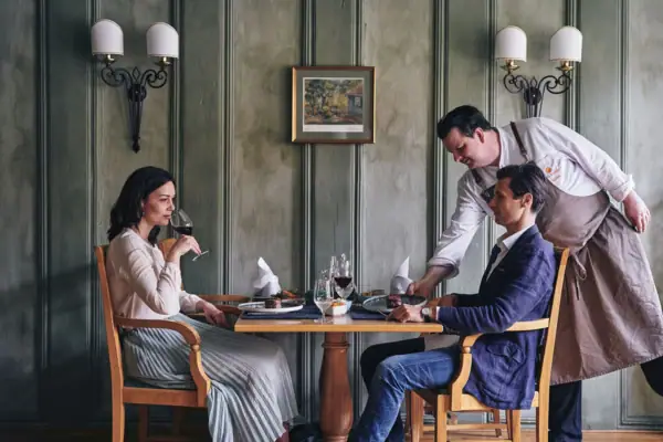 Event-Service Ein Mann bedient eine Frau an einem Tisch.