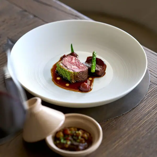 Ein Teller mit kunstvoll angerichteter Speise auf einem Tisch.