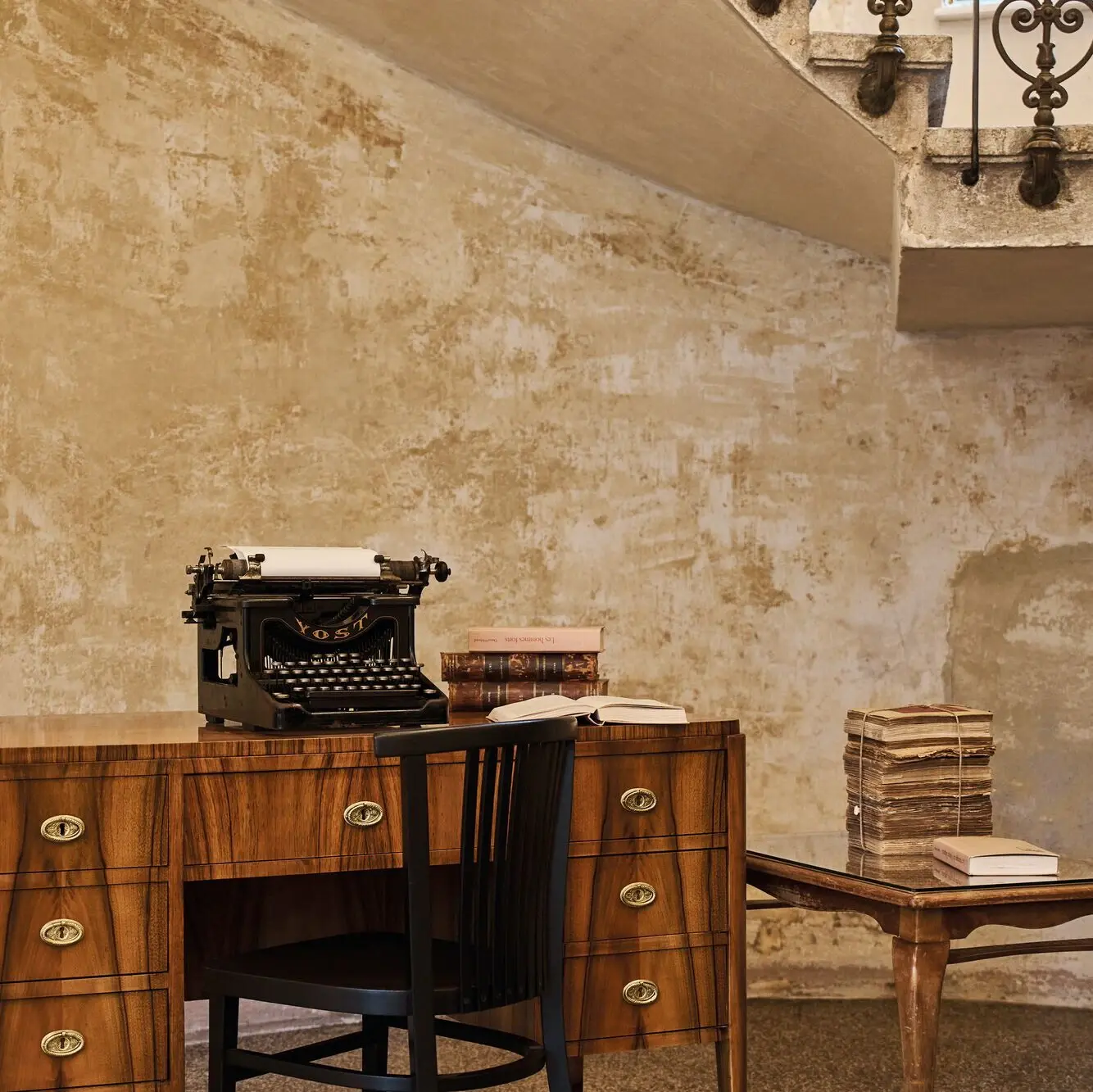 Schreiben Sie es für die Ewigkeit nieder Ein antiker Schreibtisch mit einer Schreibmaschine und alt aussehenden Büchern.
