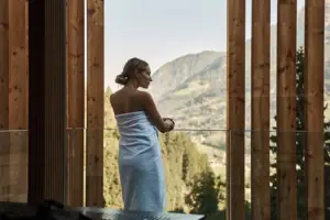 Ausblick Eine Frau in einem Handtuch steht am Fenster.