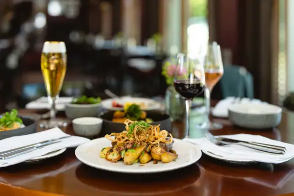 Gericht Ein Teller mit Essen auf einem Tisch, begleitet von einem Weinglas.