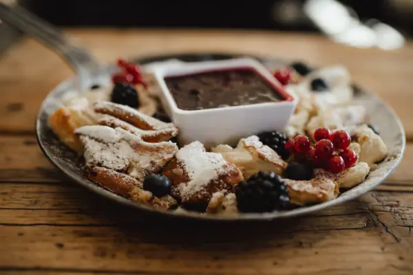 Kaiserschmarrn Ein Teller mit einer Speise und einer Sauce darauf.