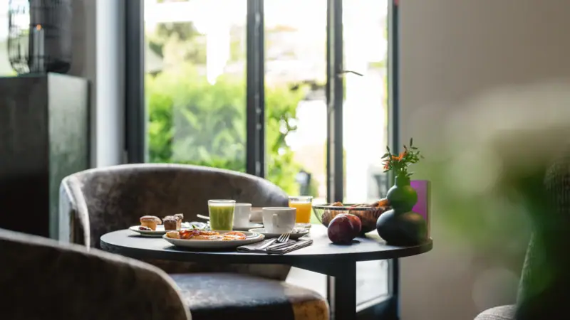 Ein gedeckter Frühstückstisch in einem Lounge-Bereich.