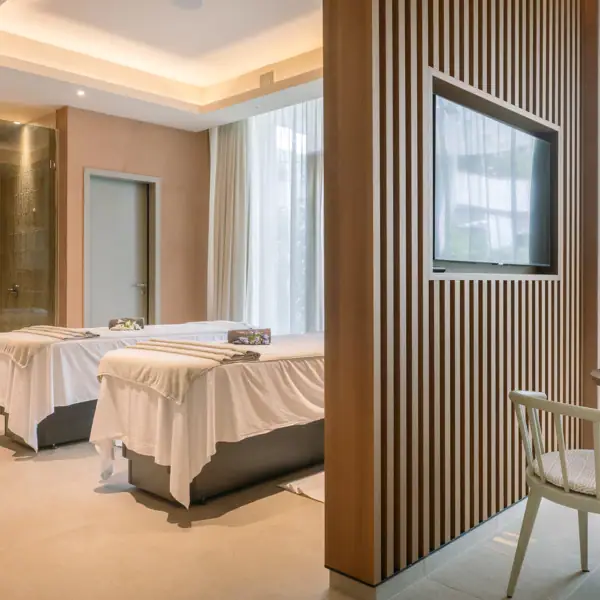 Ein Zimmer mit Massageliegen und einem Fernseher.