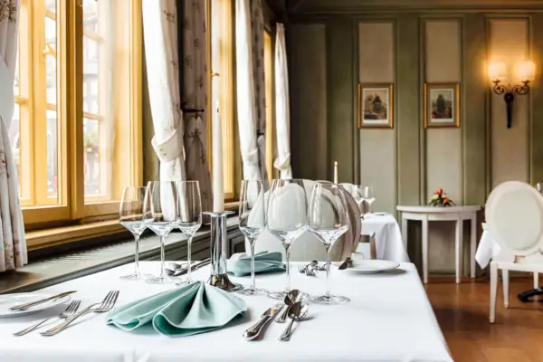 Bohlenstube Ein Tisch mit Gläsern und Besteck.