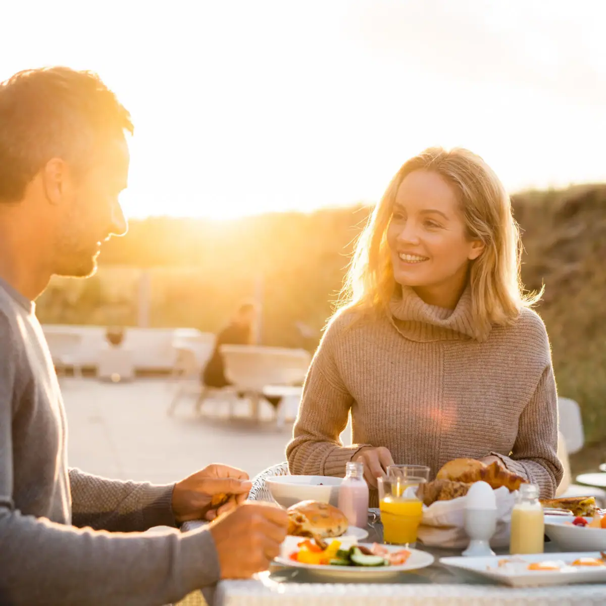 Frühstück Ein Mann und eine Frau sitzen an einem Tisch mit Essen.