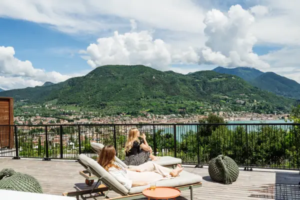 Terrasse Zwei Frauen sitzen auf einem Deck mit Blick auf ein Gewässer.