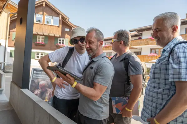 Erkundung Eine Gruppe von Männern steht im Freien und betrachtet ein Tablet.