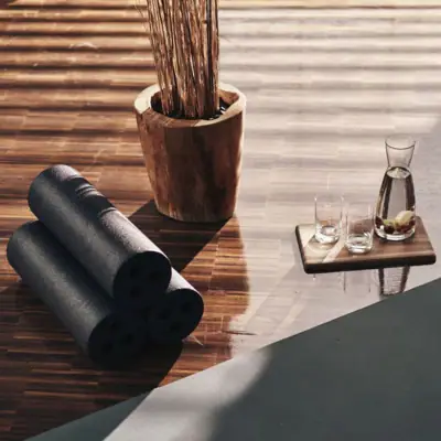 Yogamatten und Gläser auf einem Holzboden