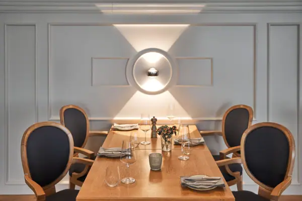 Meetingraum Ein Tisch mit vier Stühlen sowie Weingläsern und einer Vase darauf.