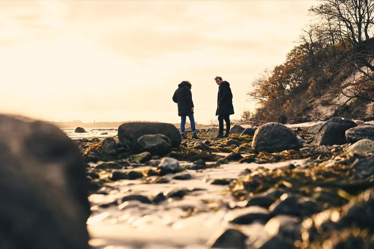Ein Paar steht auf einem felsigen Strand.