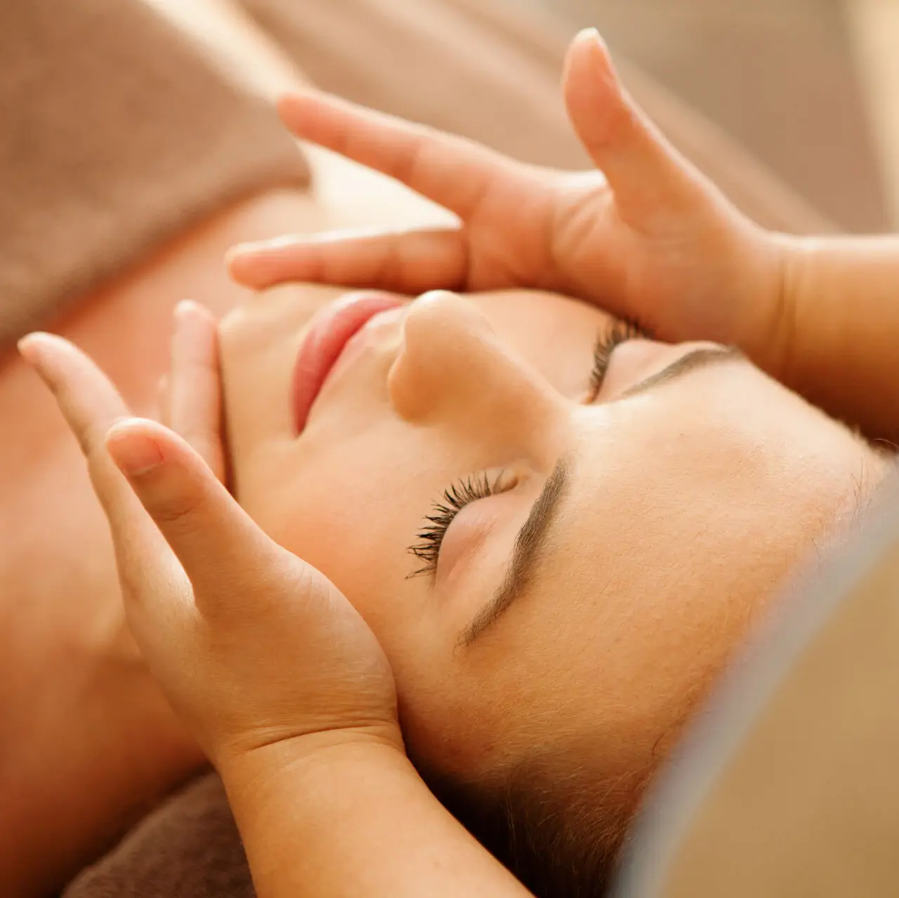 Frau bekommt eine Gesichtsbehandlung Eine Dame wird im Gesicht massiert.