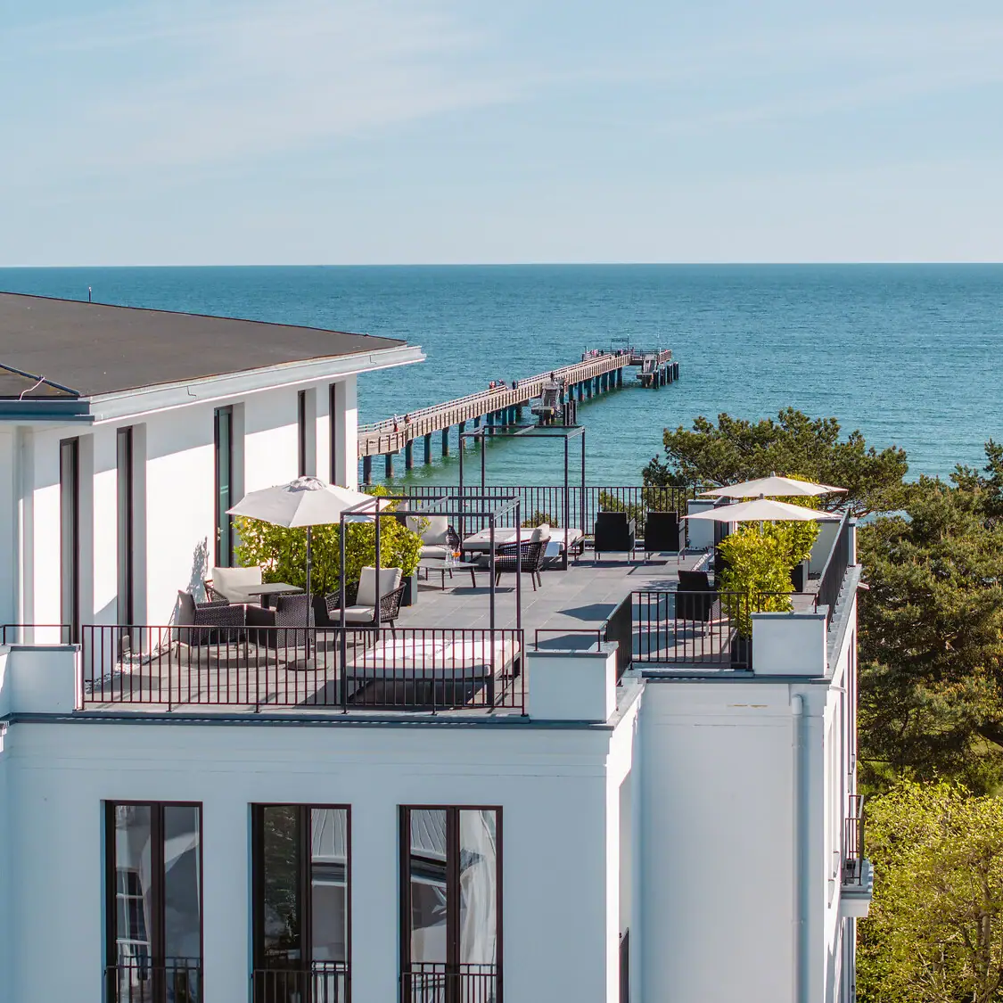 Ceres am Meer Ein Gebäude mit einem Steg und Bäumen im Freien.