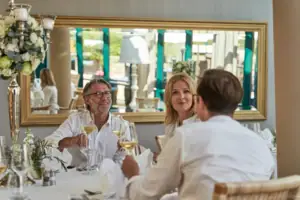 Wintergarten Eine Gruppe von Menschen sitzt an einem Tisch mit Weingläsern.