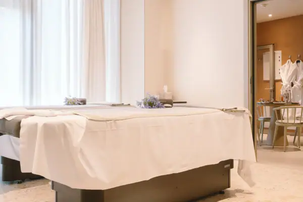 Massagetisch in einem Raum mit Vorhängen und stilvoller Inneneinrichtung