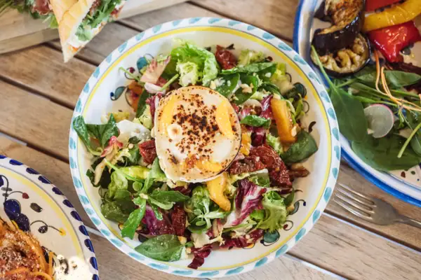 A-ROSA Salat Eine Schüssel Salat mit einem Ei darauf.