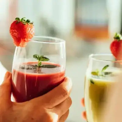 Smoothie Eine Person hält Gläser mit Früchten.