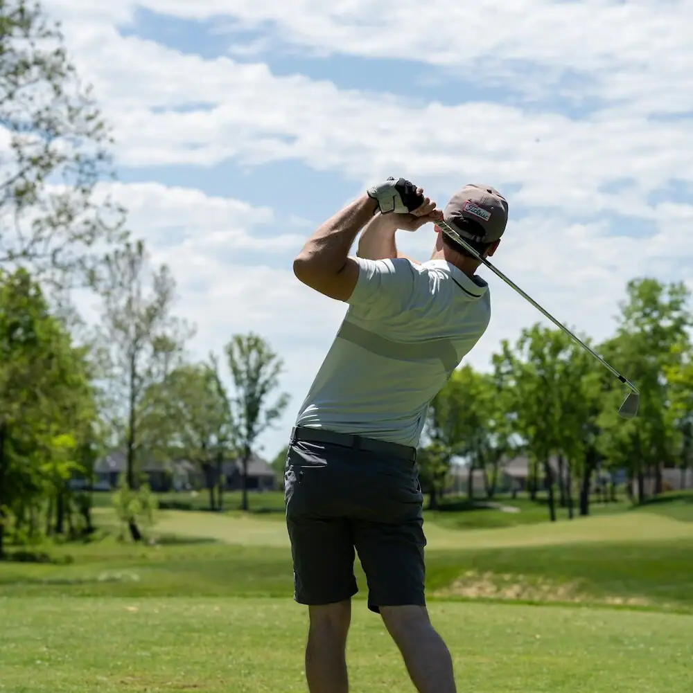 Ein Mann schwingt einen Golfschläger auf einem Golfplatz.