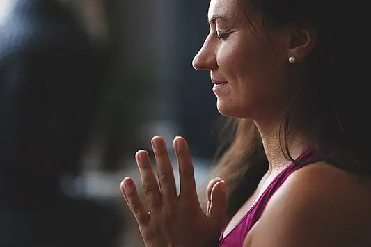 Eine Frau mit zusammengelegten Händen.