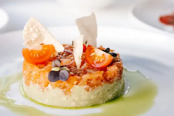 Ein Teller mit kunstvoll angerichteter Speise auf einem Tisch.