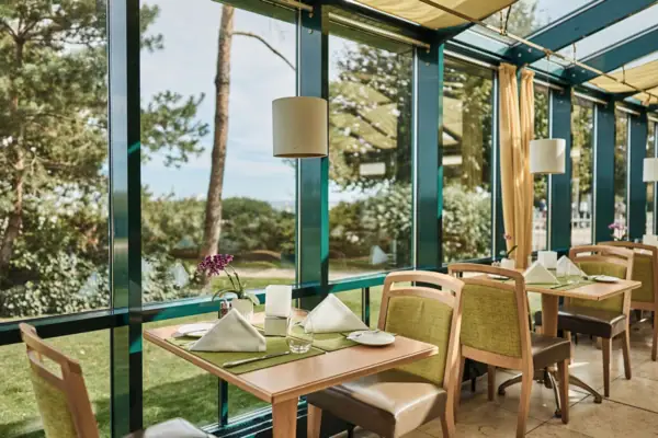 Restaurant Kiek in Ein Tisch mit Stühlen und Servietten in einem Raum mit Fenstern.