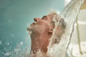 Dusche Ein Mann unter einem Wasserfall.