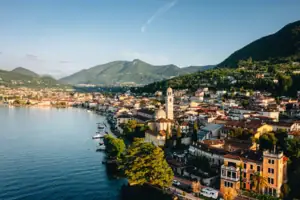 Gardasee Stadt am Wasser mit Bergen im Hintergrund und Häusern am Ufer.