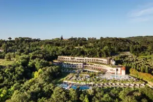 A-ROSA Hotel am Gardasee Ein Gebäude mit einem Pool, umgeben von Bäumen.