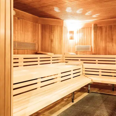 Sauna mit Holzbänken und Grill im Innenbereich