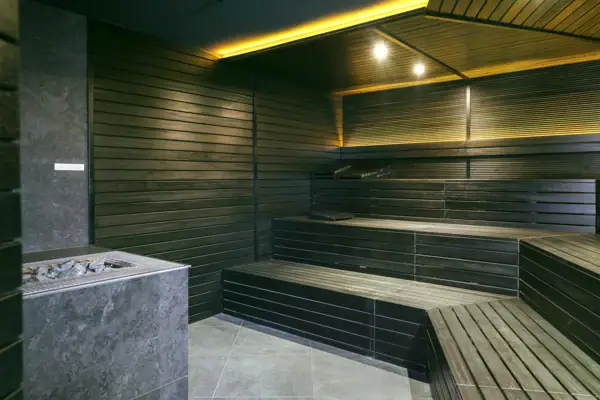 Finnische Sauna im A-ROSA Gardasee Dunkle finnische Sauna mit Holzbänken und Saunaofen im A-ROSA Gardasee.