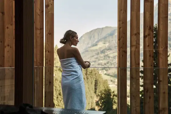 Ausblick Eine Frau in einem Handtuch steht am Fenster.