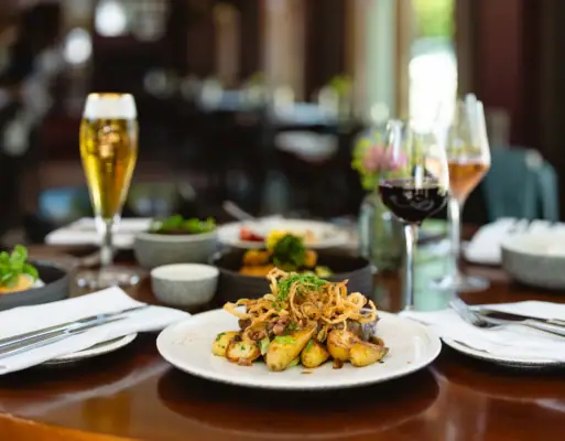 Gastronomie Ein Teller mit Essen auf einem Tisch, umgeben von einem Weinglas.