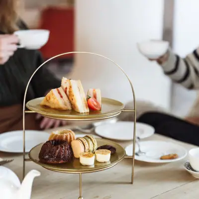 Jause Eine Gruppe von Menschen sitzt an einem Tisch mit einem Tablett voller Speisen.