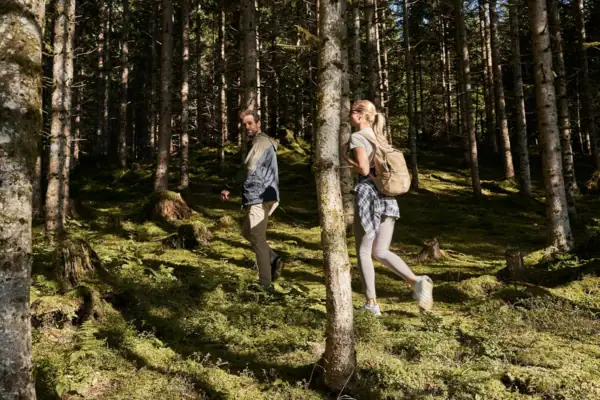 Ein Mann und eine Frau spazieren durch einen Wald.
