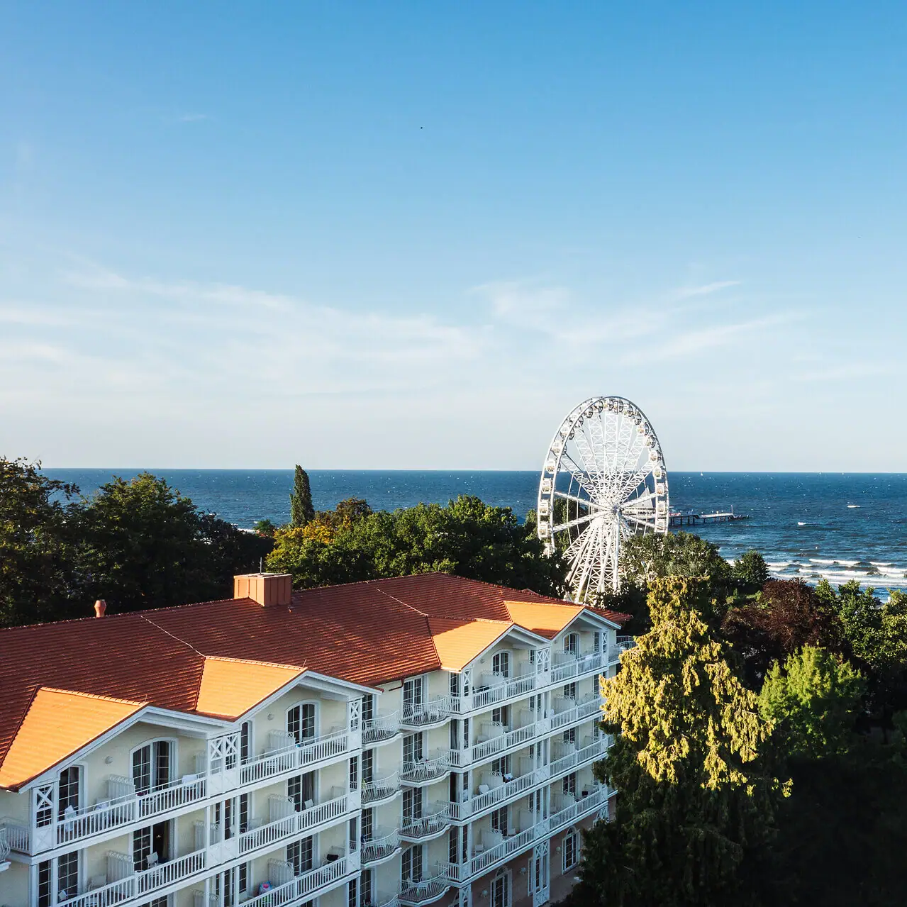 Strandidyll Heringsdorf Riesenrad in der Ferne hinter Bäumen und Wasser.