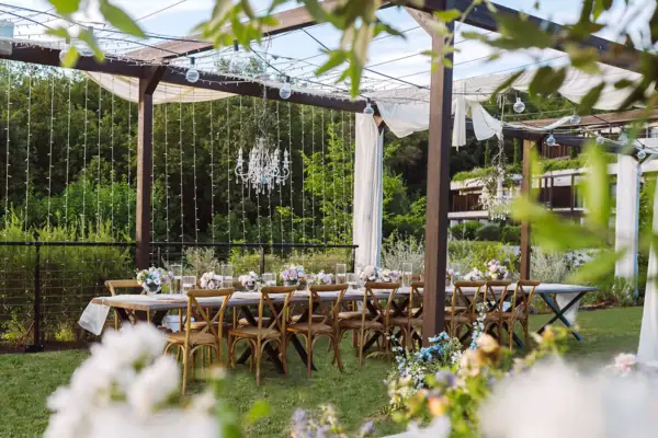 Pergola im A-ROSA Gardasee Ein für eine Feier langer, gedeckter Tisch im Garten vom Hotel. Der Tisch ist festlich gedeckt und mit Blumen geschmückt.