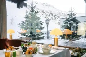 Frühstück Ein Tisch mit Geschirr und Speisen vor einem Fenster.