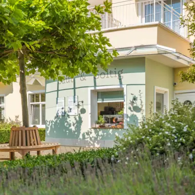 Ein Gebäude mit einer Bank und einem Baum davor.