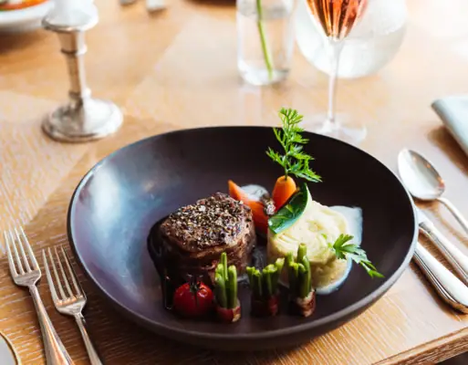 Gastronomie im A-ROSA Ostseehotel Kühlungsborn Ein Teller mit kunstvoll angerichteter Speise auf einem Tisch.