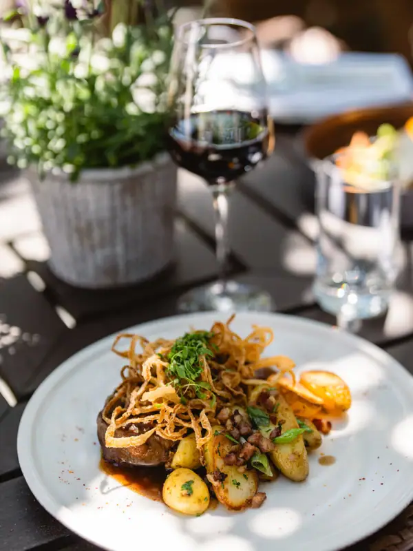 A-ROSA Gericht Ein Teller mit Essen und ein Glas Wein.