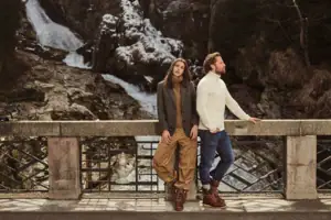 Terrasse Ein Mann und eine Frau lehnen an einem Geländer im Freien.
