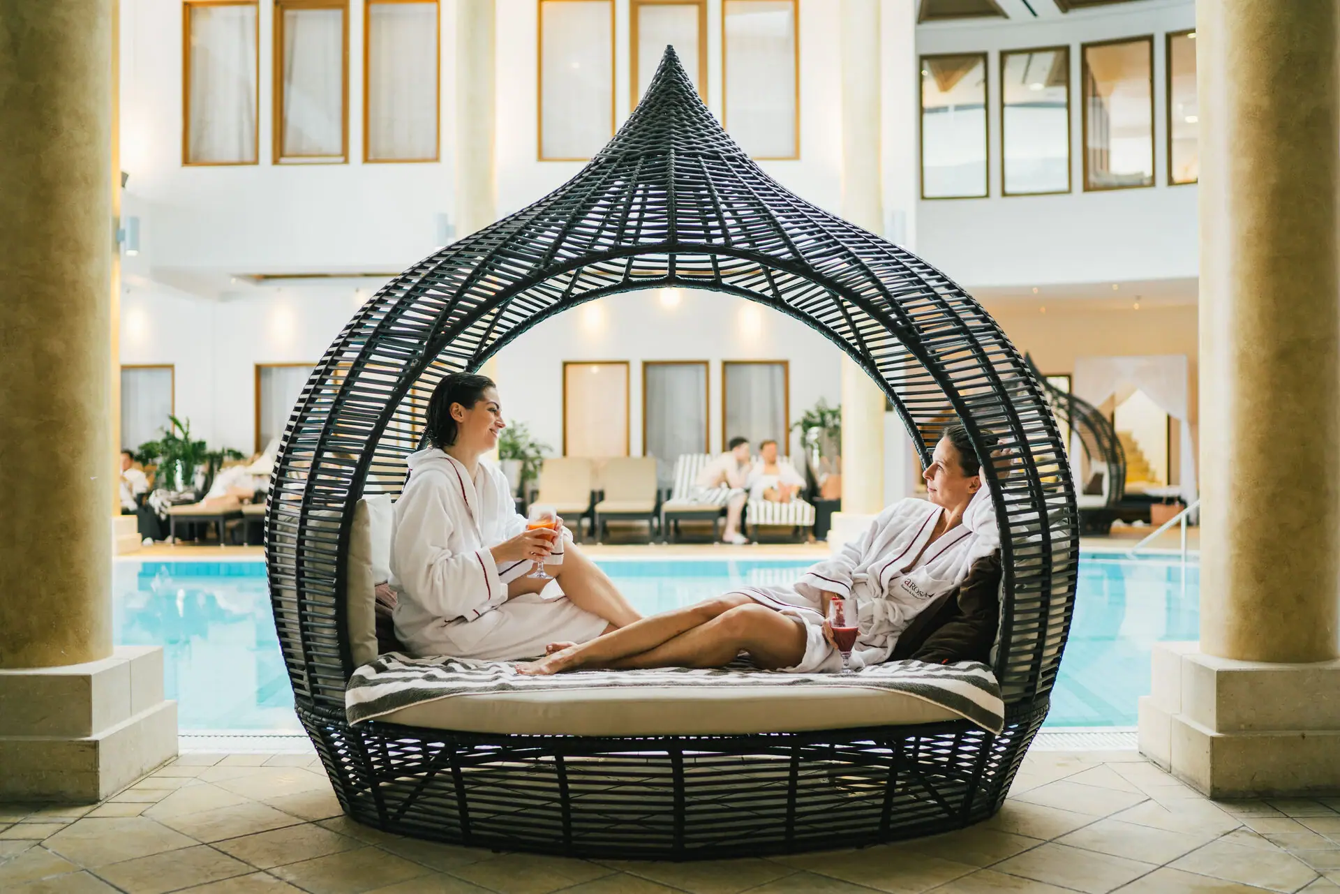Innenpool Zwei Frauen sitzen in einem Korbstuhl.
