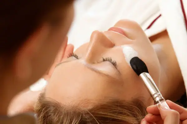 Unser größtes Organ, die Haut, will gepflegt sein. Einer Frau wird eine Creme mit einem Pinsel aufgetragen.