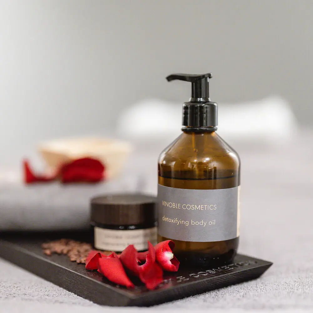 Vinoble Cosmetics Angeordnete Pflegeprodukte mit Rosenblättern