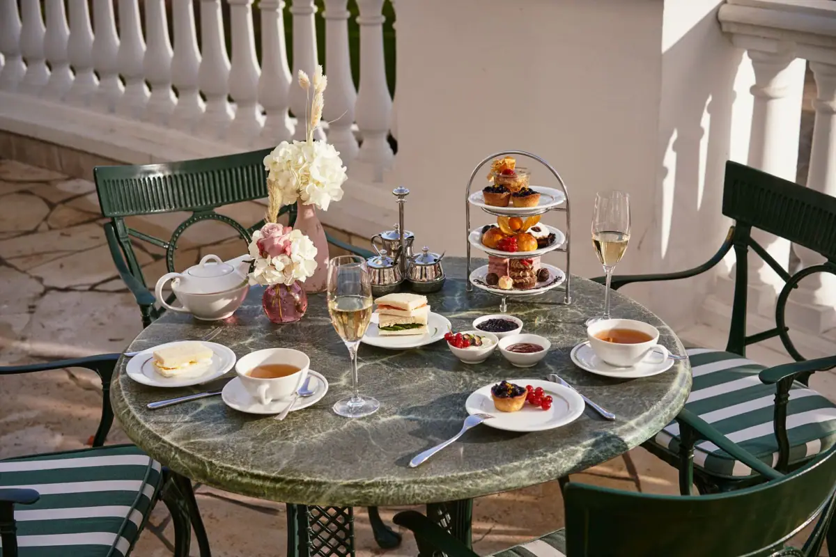 Tea Time Ein Tisch mit Geschirr und Speisen darauf.